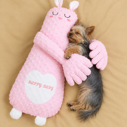Yorkie sleeping in the arms of the pink bunny patting pillow